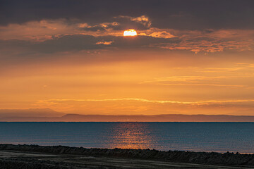 sole che sorge all'alba sopra il mare Adriatico e colora l'ambiente di arancione, visto dalla costa della regione Veneto