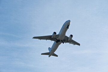 Obraz premium Airplane in the cloudy sky. White Plane Climbing Through Clouds Half a Minute Post-Takeoff.