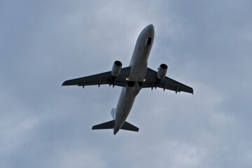 Airplane in the cloudy sky. White Plane Climbing Through Clouds Half a Minute Post-Takeoff.