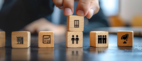 Team collaboration concept with wooden blocks and human icons arranged by hand. Symbolic representation of management, organization, leadership, teamwork and business structure.