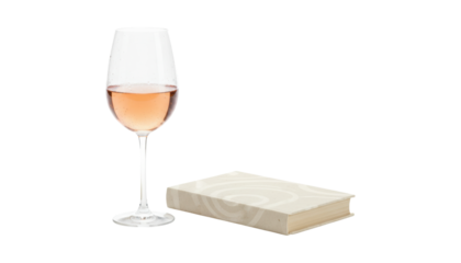 Tall elegant glass of rosé sparkling wine with delicate bubbles stands next to a small hardcover book with a patterned cover, creating a sophisticated and relaxing still life scene
