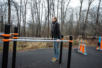 outdoor gymnast stability, focused gymnast maintains posture amid cloudy outdoors, skilled competitor executes balance routine in serene outdoor park setting with overcast weather