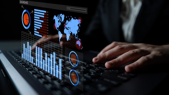 A business professional engages with a digital dashboard on their laptop, analyzing key data and statistics in a modern office setting at night. Impute - Powered by Adobe