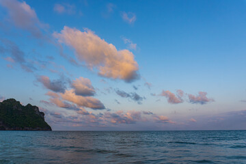 Serene Sunset Over Calm Ocean Waves and Lush Green Cliff