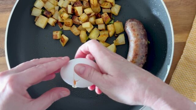 Cooking Fried Eggs in a Pan with Sausages and Fried Hash Brown Potatoes