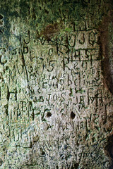 Words and letters carved into an ancient stone wall