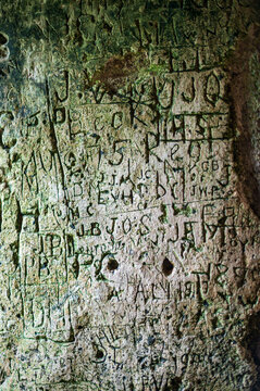 Words and letters carved into an ancient stone wall