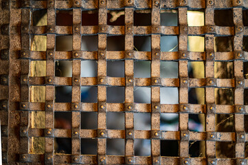 An ancient metal grid over a window