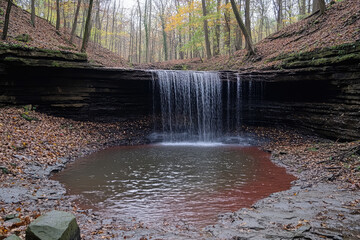 small forest waterfall in autumn background