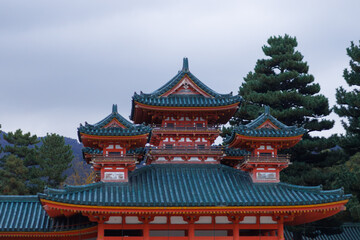 Obraz premium Traditional Red Japanese Temple Gate With Green Tiled Roof, Lanterns, And Wooden Details. Japan. Osaka Shimogamo Shrine