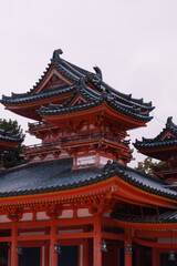Fototapeta premium Traditional Red Japanese Temple Gate With Green Tiled Roof, Lanterns, And Wooden Details. Japan. Osaka Shimogamo Shrine