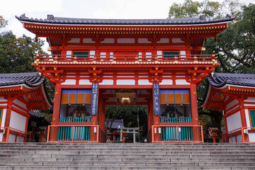 Traditional Red Japanese Temple Gate With Green Tiled Roof, Lanterns, And Wooden Details. Japan. Osaka Shimogamo Shrine