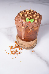 Panettone with melted chocolate frosting and peanuts alongside caramel crunch_vertical.