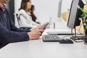 People working in a coworking space using computers and mobile devices