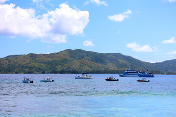 Boats Anchored in Clear Tropical Waters with Mountainous Island