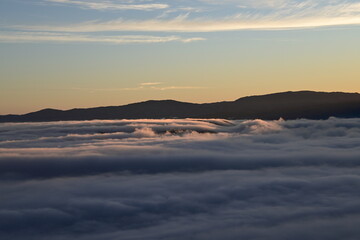 Stunning sunrise from a mountain top over the clouds