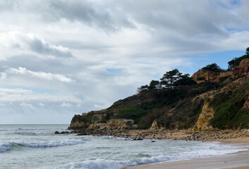 Aerial seascape and coastline cliffs of Praia do Barranco das Belharucas beach, in Algarve region in South Portugal. Praia do Barranco das Belharucas beach, Albufeira, Algarve, Portugal.