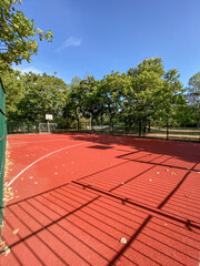 empty outdoor basketball court with red surface