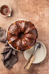 Chocolate marble bundt cake or zebra cake with chocolate glaze on brown table background top view