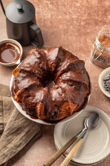 Chocolate marble bundt cake or zebra cake with chocolate glaze on brown table background