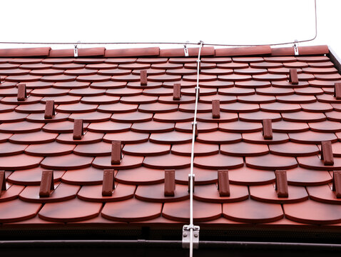 Expert installation of ceramic roof tiles equipped with snow guards and an advanced lightning protection system, highlighting professional craftsmanship, and durable materials. 