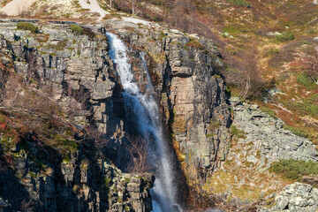 Mountain waterfall cascading down rocky cliff in Norway