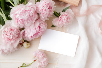 Elegant feminine wedding or birthday flat lay with pink peonies and blank card for invitations or messages