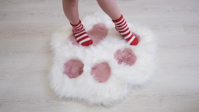 Teenager girl wearing funny striped socks touching fluffy carpet and enjoying its softness and warmth. The plush carpet felt silky smooth under my feet, making every step a joy.
