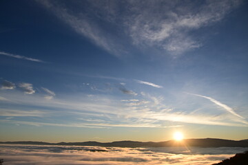 Obraz premium Stunning sunrise from a mountain top over the clouds