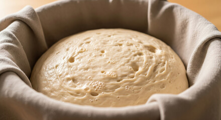 Dough swelling and expanding with bubbles during the rising process in a bowl in a kitchen setting
