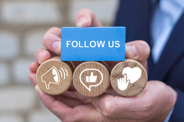 Business person holding blocks with icons sees the words FOLLOW US. Follow us communication web online media content concept.