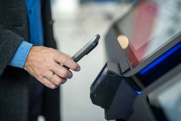 Person paying contactless with smartphone at terminal