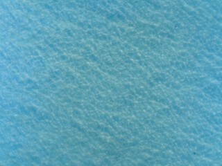 High angle aerial drone view of crystal clear turquoise ocean water surface with sunlight...