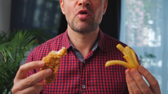 Junk food advertisement concept. Man eating fried chicken, enjoying fast food.