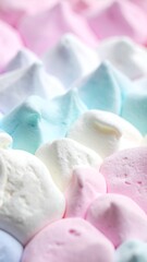 Close-up of soft pastel-colored marshmallows in pink, blue, and white, showing their fluffy texture and gentle color gradient.