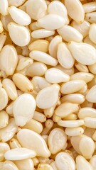 Close-up view of numerous white sesame seeds scattered evenly, highlighting their natural texture and shape.