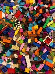 A disorganized and colorful overhead view of hundreds of interlocking plastic toy bricks in various shapes, sizes, and vibrant colors. - Vista aérea colorida e desorganizada de centenas de blocos de m © marcomoreira