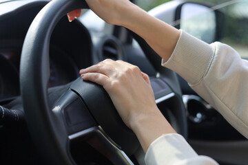 Close up Hands on the steering wheel of the car and honking.