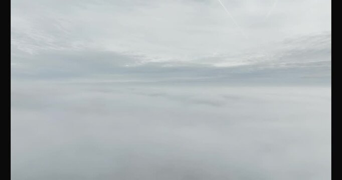 aerial footage of a pale sun above the mist