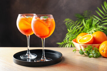 Fototapeta premium Refreshing spritzer cocktail with mint and oranges on wooden table