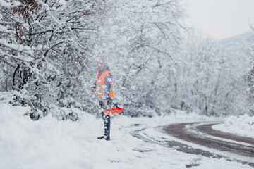 Hardworking man clearing snow with a shovel after a heavy snowfall