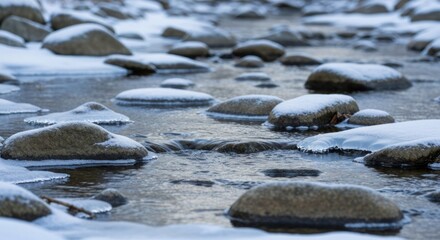 Fototapeta premium A wintry creek bed, stones covered in snow and ice