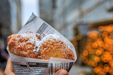 Woman holds Oepfelkuechli apple fritters, Zurich Christmas market, Switzerland