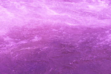 Purple water bubbles on the surface ripples. Defocus blurred transparent pink colored clear calm water surface texture with splash and bubbles. Water waves with shining pattern texture background