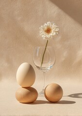 Delicate still life with flower, eggs, glass, and soft, neutral background