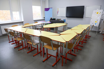Classroom with yellow desks and chairs at school