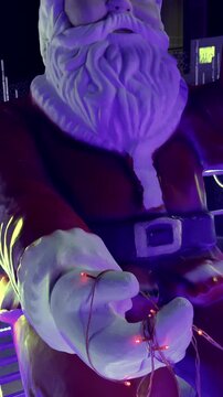 Santa Claus statue holding red string lights