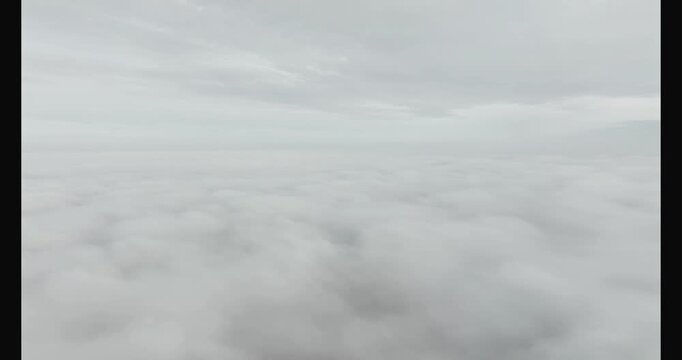 aerial footage of a pale sun above the mist