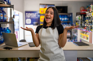Excited young woman owner welcoming customers at her small business retail counter