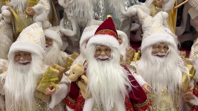 Row Of Santa Dolls On Shop Display Filling Shelves With Varied Red And White Costumes, Long Beards, Glittering Accessories HandCrafted Looks Suggest Bustling Holiday Market Stall, Festive
